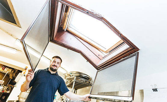 installer holding open a velux window fly screen