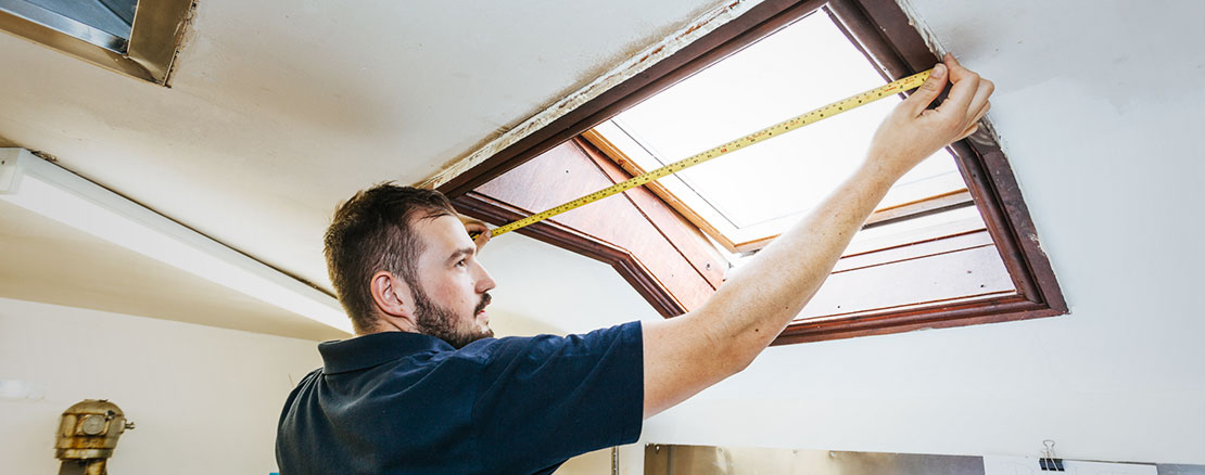installer measuring up a window for a fly screen